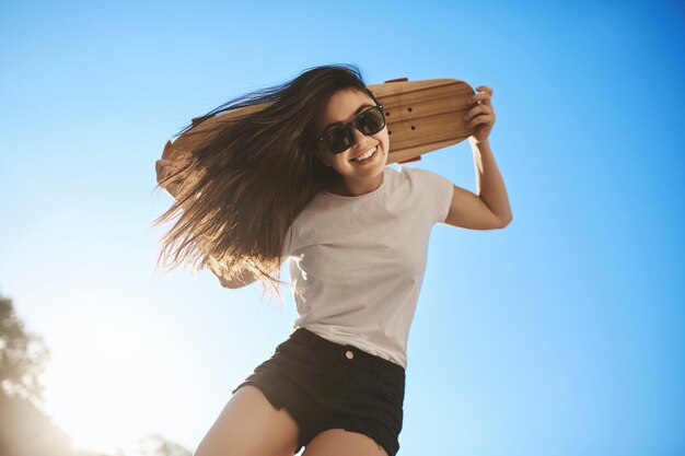 Lowangle view carefree happy young hipster girl having fun enj