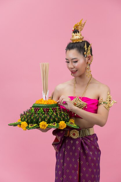 Loy Krathong Festival. woman in thai traditional outfit holding decorated buoyant