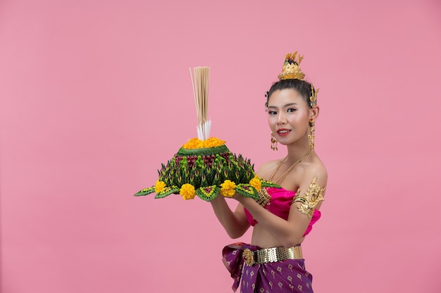 Free photo loy krathong festival. woman in thai traditional outfit holding decorated buoyant