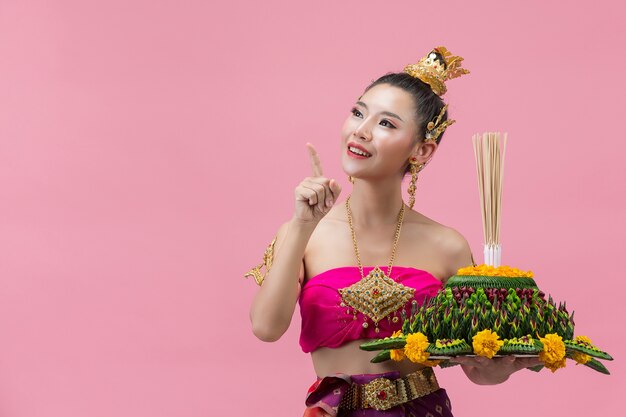 Loy Krathong Festival. woman in thai traditional outfit holding decorated buoyant