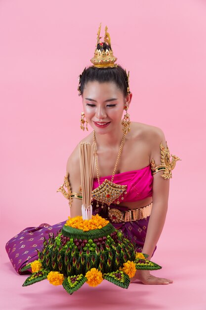 Loy Krathong Festival. woman in thai traditional outfit holding decorated buoyant