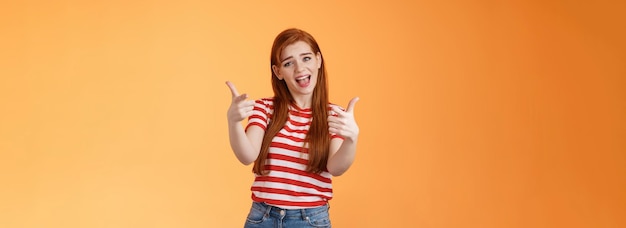 Free photo lucky cool redhead sassy girl singing pointing camera talking about you congratulate friend good job