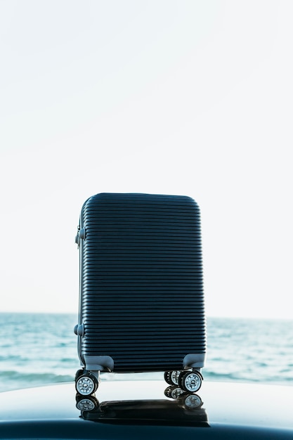 Luggage sitting on top of car near sea