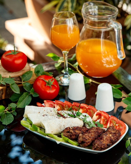 Lula kebab platter with tomato, bell pepper, flatbread and onion