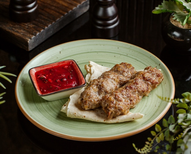 Foto gratuita kebab di lula servito con focacce e salsa di melograno, cipolla ed erbe