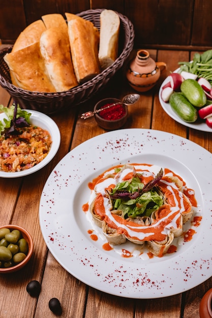 Lula kebab slices wrapped in flatbread garnished with tomato sauce vertical