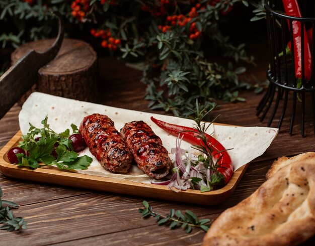 Lule kebab in barbecue sauce with red hot pepper