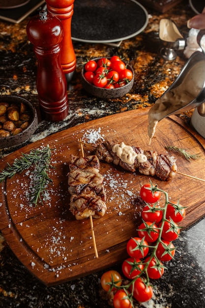 Lule kebab on stick with cream sauce on top