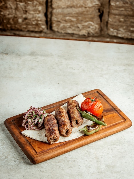 Lule kebab with sliced onions and fried tomato