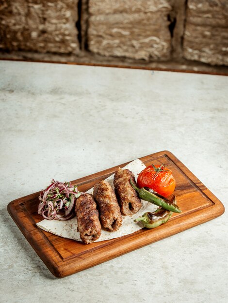 Lule kebab with sliced onions and fried tomato