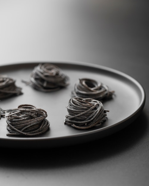 Free photo lumps of dark pasta on a dark plate