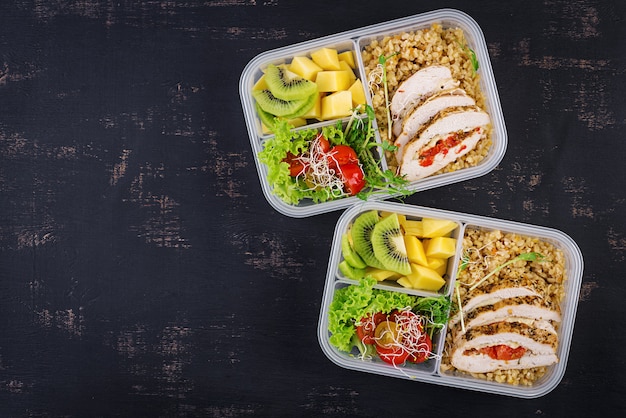 Free photo lunch box  chicken, bulgur, microgreens, tomato  and fruit. healthy fitness food. take away. lunchbox. top view