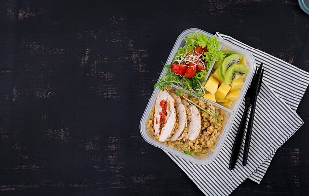 Lunch box  chicken, bulgur, microgreens, tomato  and fruit. Healthy fitness food. Take away. Lunchbox. Top view