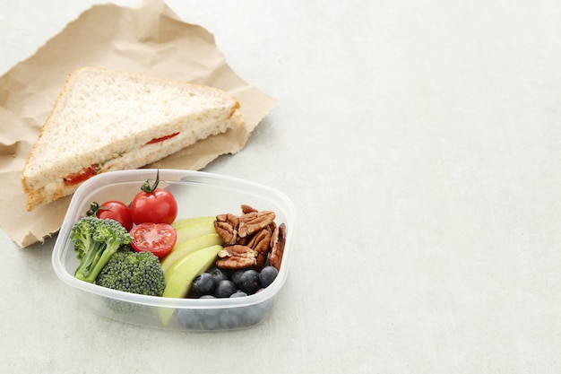 Lunch box with healthy food and sandwich
