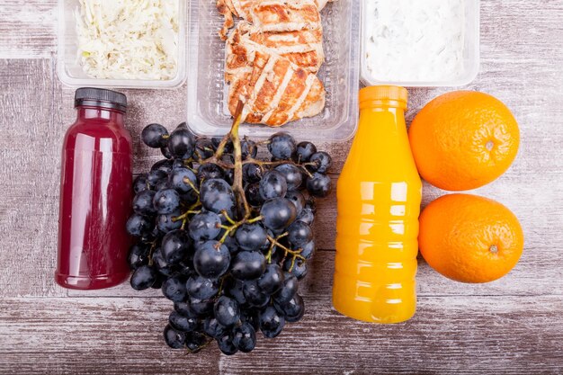 Lunch packed in different boxes. Fresh and healthy eating on wooden background