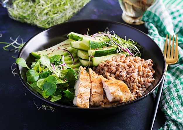 Foto gratuita insalata di pranzo. ciotola del buddha con porridge di grano saraceno, filetto di pollo alla griglia, insalata di mais, microgreens e daikon. cibo salutare.