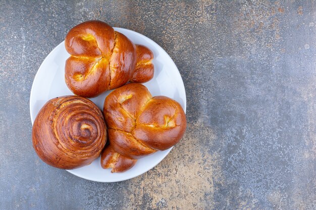 Lunch serving of sweet buns on a platter on marble surface