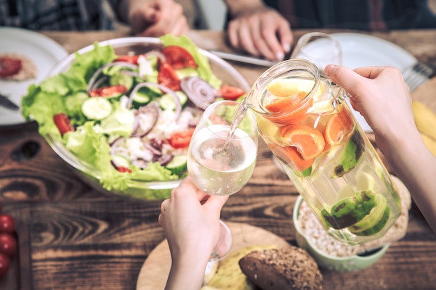 テーブルで昼食、新鮮なフルーツ、飲み物の概念と夏の飲み物を注ぐ