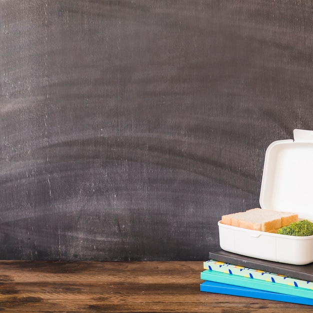 Lunchbox on heap of notebooks