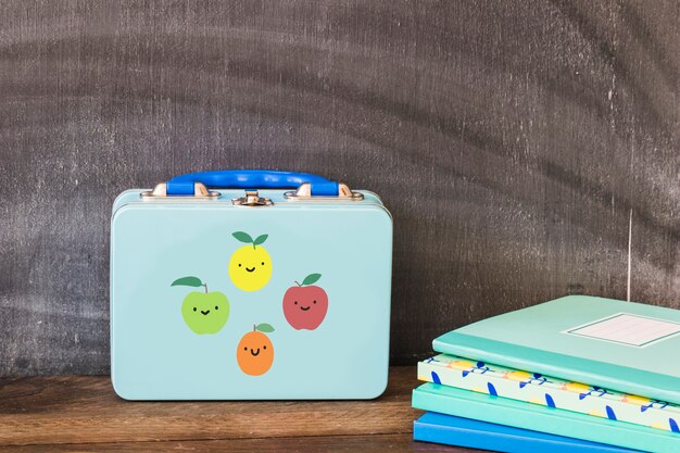 Lunchbox near stack of notebooks