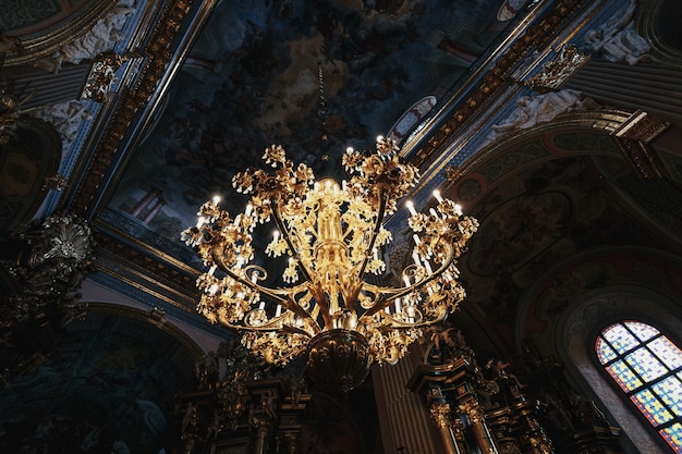 Luxurious golden lamp hangs under the ceiling