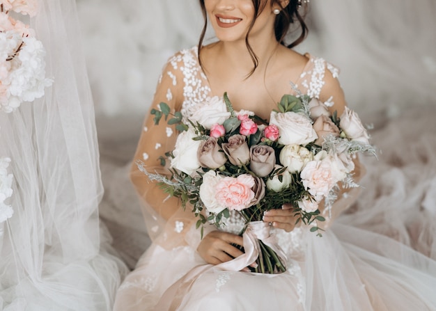 Роскошная невеста держит большой букет цветов