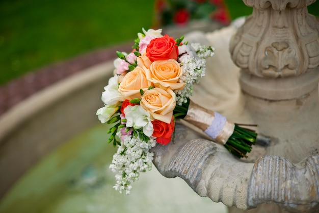 Luxury colorful bride's bouquet on old fontain