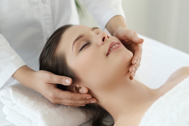 Lying woman receiving a massage. Craniosacral therapy