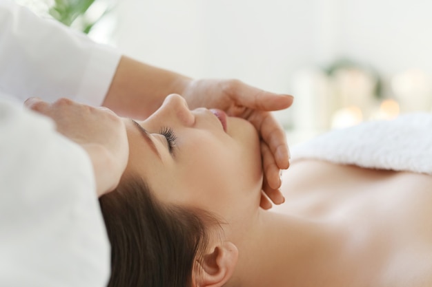Lying woman receiving a massage. Craniosacral therapy