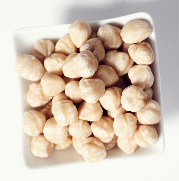 Macadamia nuts on white bowl