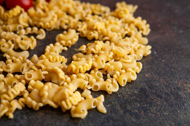 Macaroni on a dark textured background. high angle view.