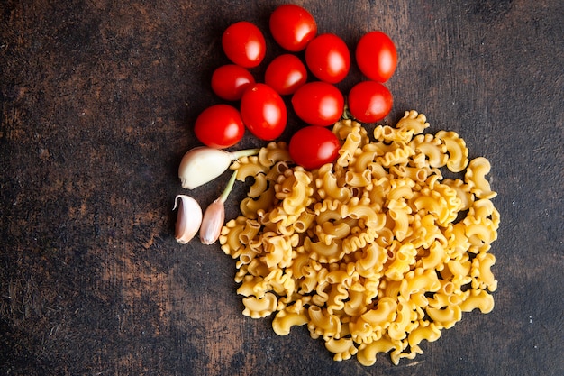 Macaroni with tomatoes and garlic on a textured background