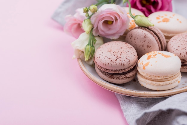 Macarons on plate with roses and copy space