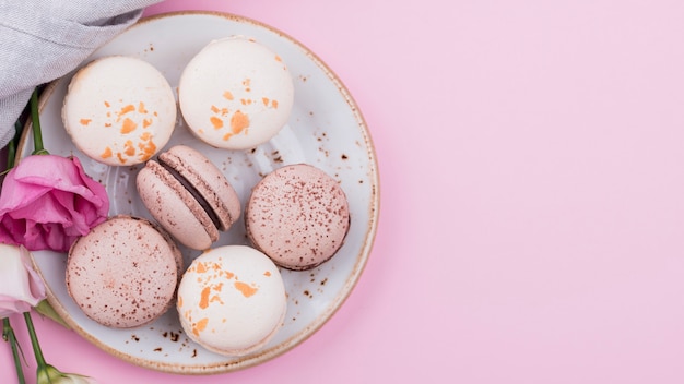 Macarons on plate with roses and copy space