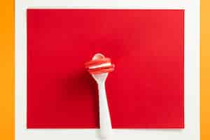 Free photo macaroon in a spoon with red background