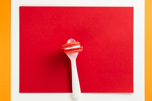 Macaroon in a spoon with red background