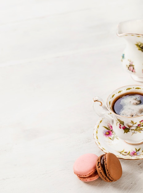 Macaroons and ceramics coffee cup on wooden background