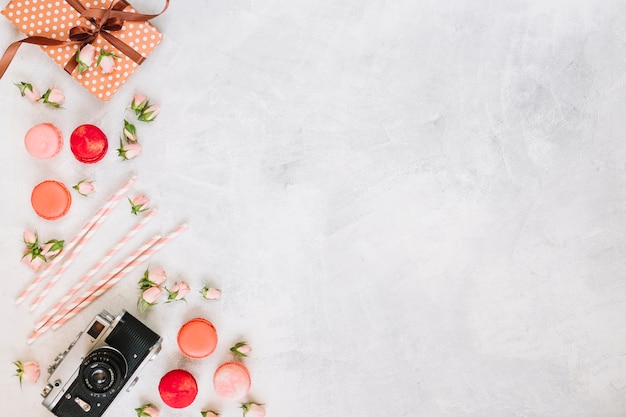 Macaroons and flowers near camera and present