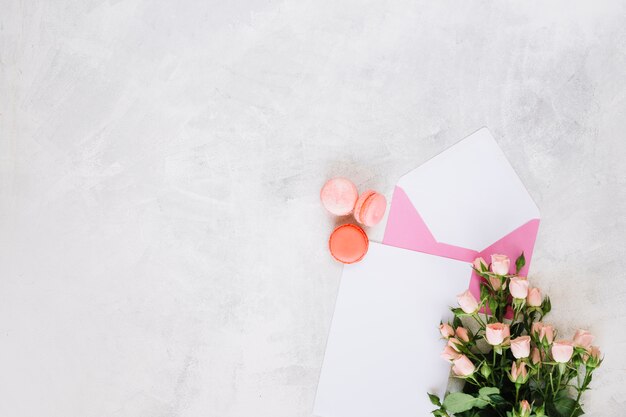 Macaroons near envelope and bouquet
