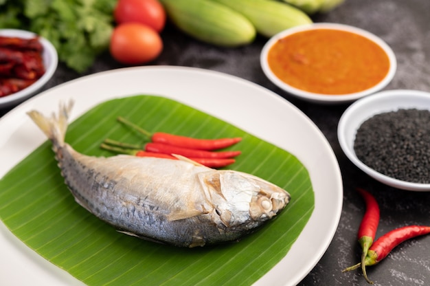 Free photo mackerel placed on banana leaves on a white plate.