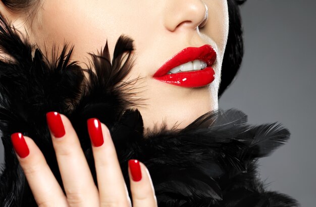 패션 빨간 손톱과 관능적 인 입술을 가진 여자의 매크로 사진