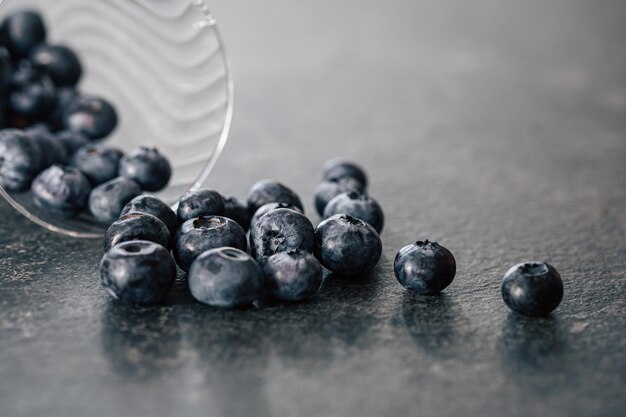 Free photo macro photography blueberries scattered on a dark surface