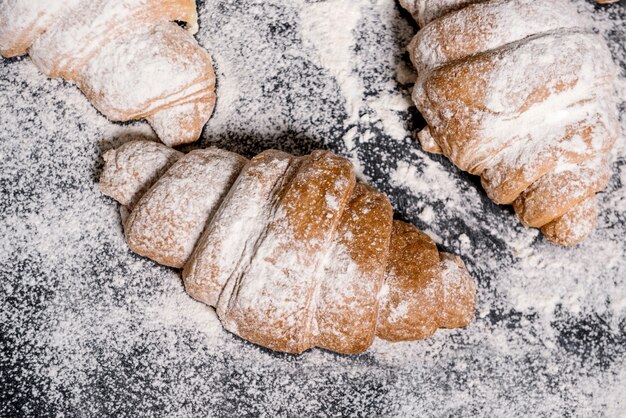 Macro picture of croissants with powdered sugar on grey table.