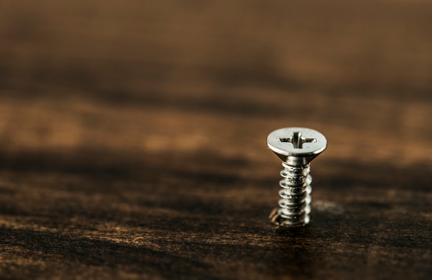 Macro shot of screw on wooden background