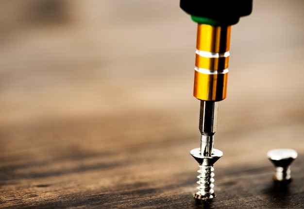 Macro shot of screw on wooden background