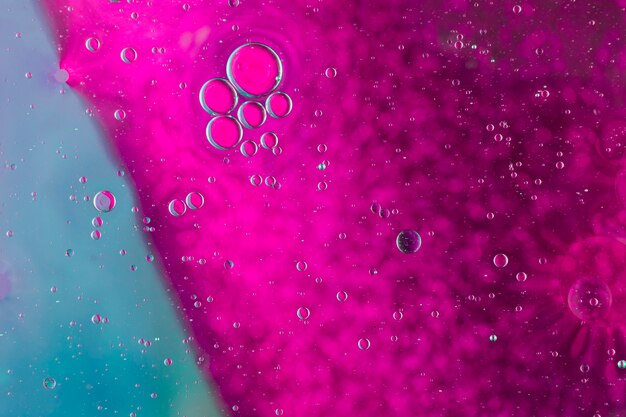 Макросъемка капель воды на розовом фоне