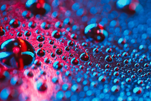 분홍색과 파란색 배경 표면에 매크로 물방울