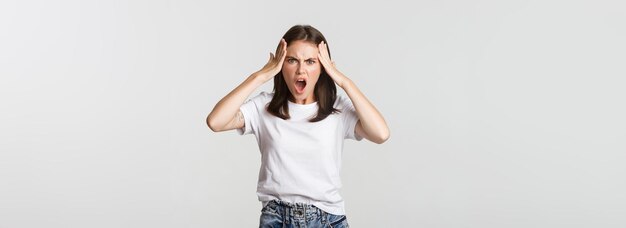 Mad and frustrated young woman looking shocked at camera