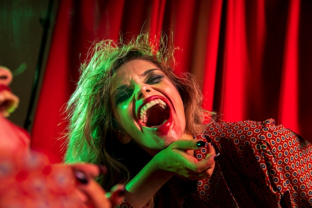 Бесплатное фото Безумный хэллоуин клоун женщина смеется