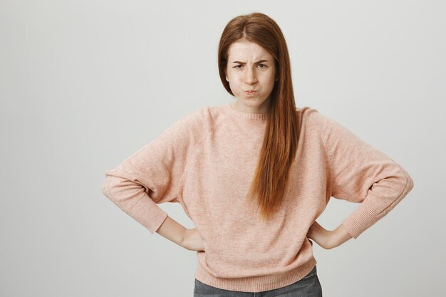 Mad pretty redhead girl sulking, scolding someone